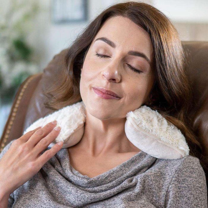 Woman relaxing with Cozy Microwavable Cream Warmies Neck Wrap.