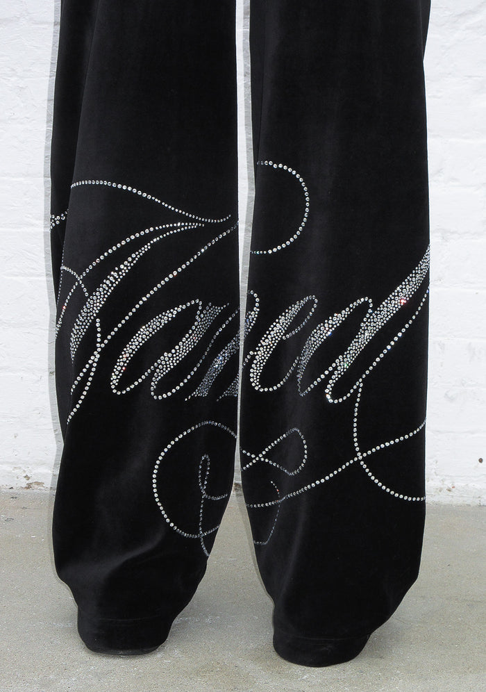 Detail shot of enemy rhinestone velour sweatpants black showcasing rhinestone embellishments on the fabric.