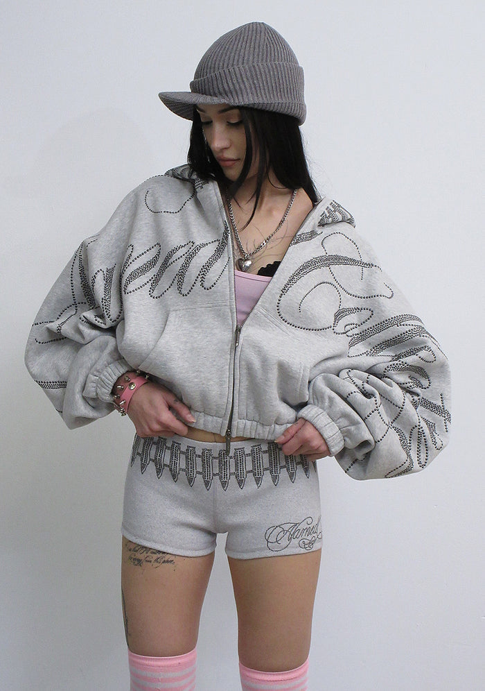Model wearing grey marl hotpant shorts with studded design and oversized grey marl jacket.