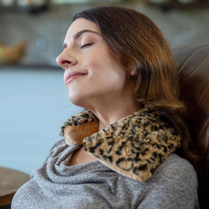 Woman relaxing with Cozy Soft Heatable Leopard Warmies Neck Wrap.