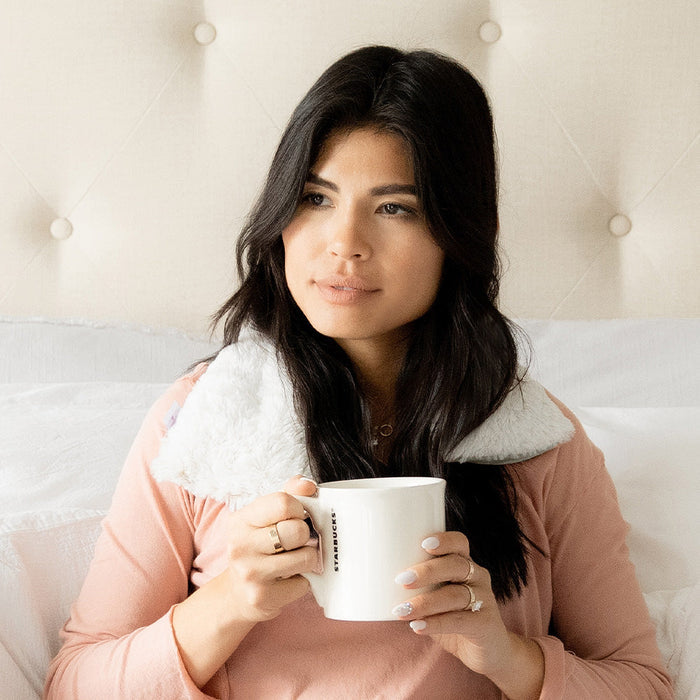 Woman relaxing in Soothing Warmies Neck Wrap in Marshmallow Gray