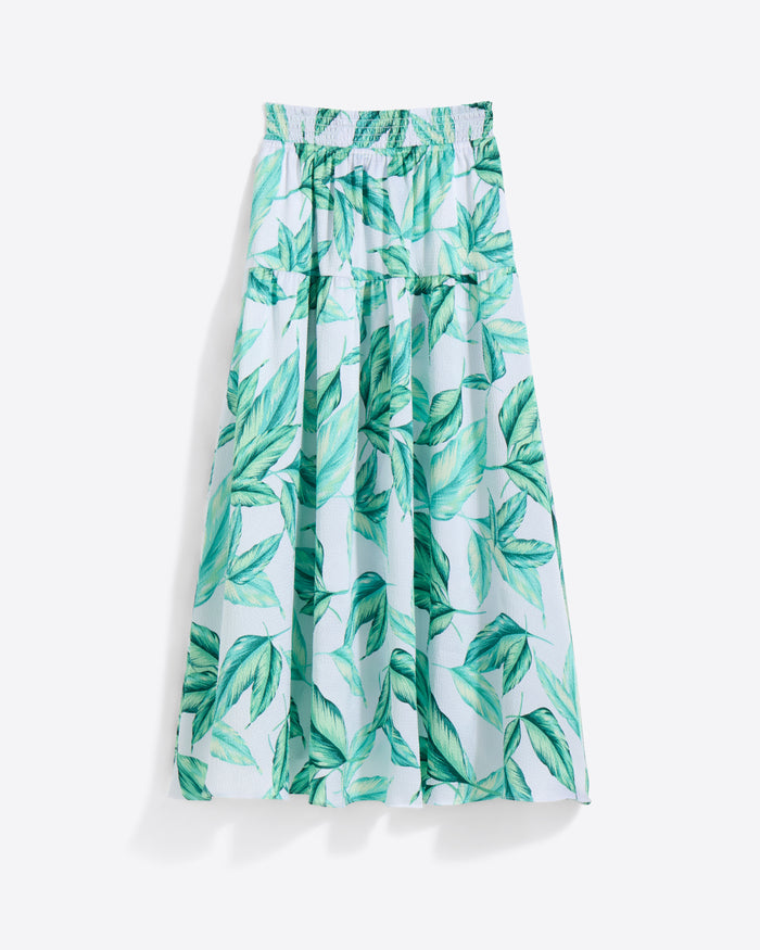 The Draper James Midi Skirt in Hammered Satin is a light blue, green leaf-patterned midi with a smocked and elastic waistband, shown on a white background.