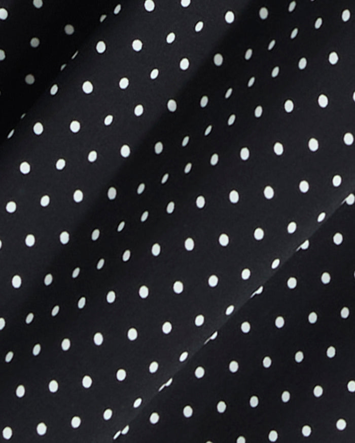 Close-up of the Draper James Midi Skirt in Polka Dot, featuring black fabric with evenly spaced white dots and subtle folds—ideal for a smocked waist or a flowing silhouette.