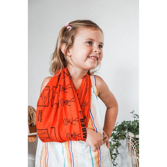 Young girl wearing an orange scarf with black graphics against a white background