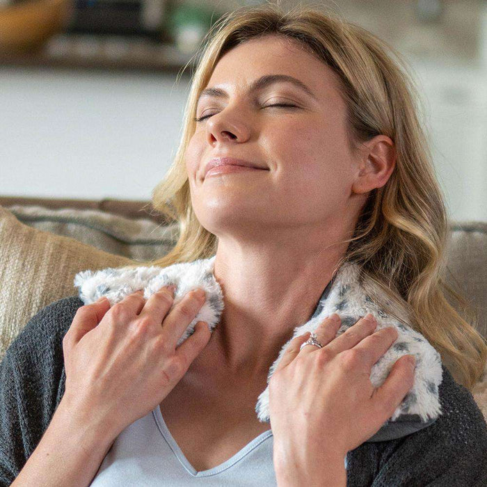 Adult relaxing with Cozy Microwavable Snowy Warmies Neck Wrap.