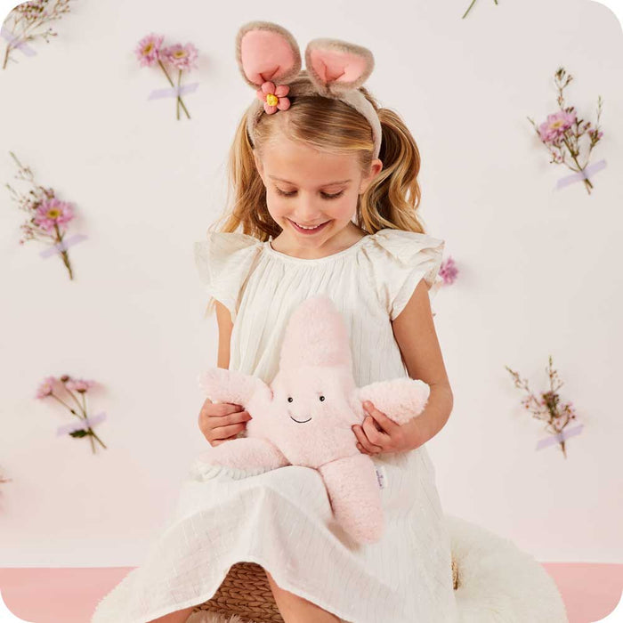 Child smiling and holding Cute Weighted Lavender Scented Starfish Stuffed Animal Heating Pad Warmies
