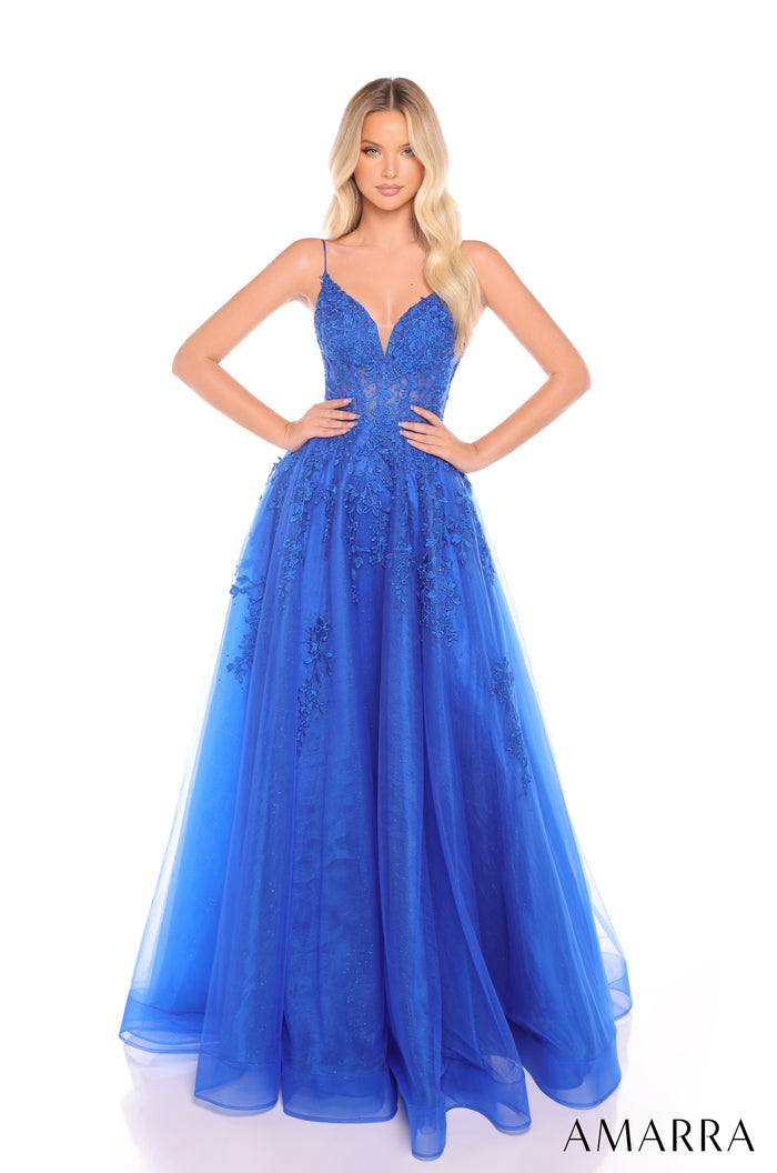 A model wears a Royal Blue floor-length gown with lace bodice and tulle skirt, posing against a white background.