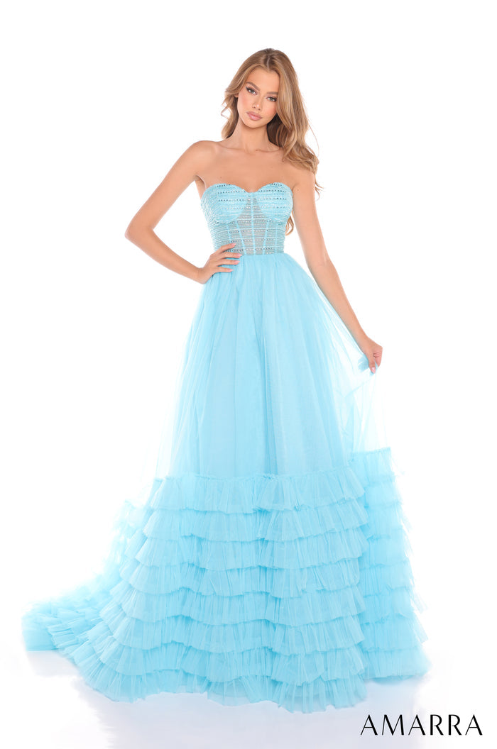 A strapless light blue ball gown with a corset bodice and tiered ruffled skirt on a fashion model.