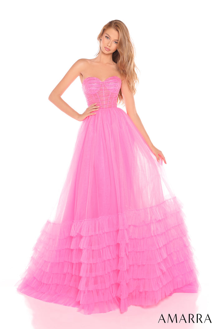 A model wears a sweetheart strapless ball gown in Hot Pink with tiered tulle skirt and beaded bodice.