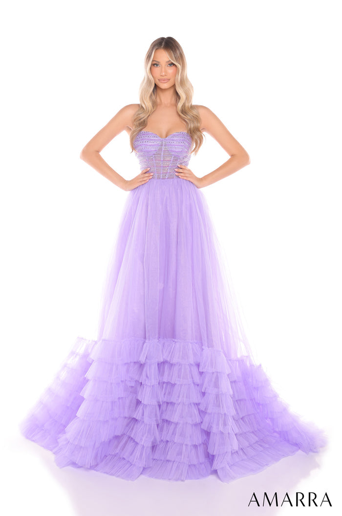 A model wears a strapless, lilac tulle ball gown with a structured bodice and ruffled tiered skirt.