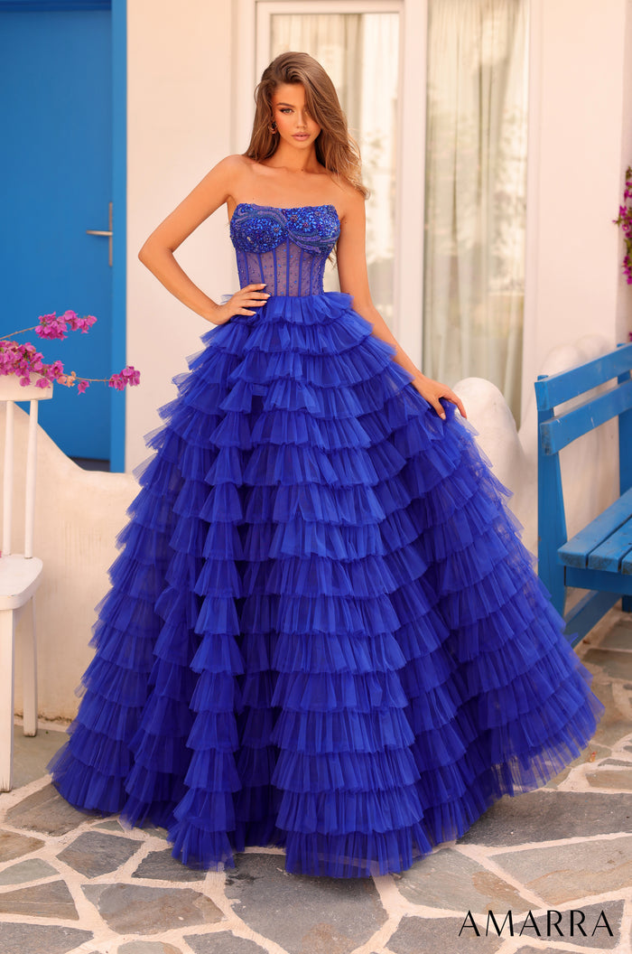A strapless ball gown in Bright Royal blue tulle with a corset bodice and dramatic tiered ruffled skirt.