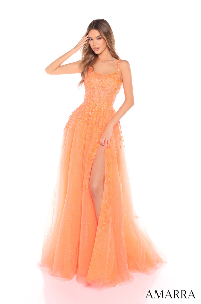A woman wears a flowing Neon Orange tulle gown with a high slit and floral lace details.
