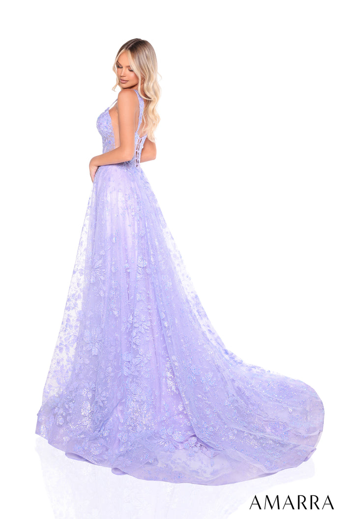 A blonde woman in a lavender lace ball gown with a sweeping train, posing in a three-quarter view.