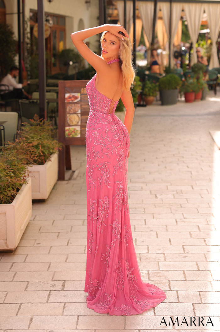 A slim-fitting bright pink sequined gown with a long train poses on a brick pathway near potted plants.