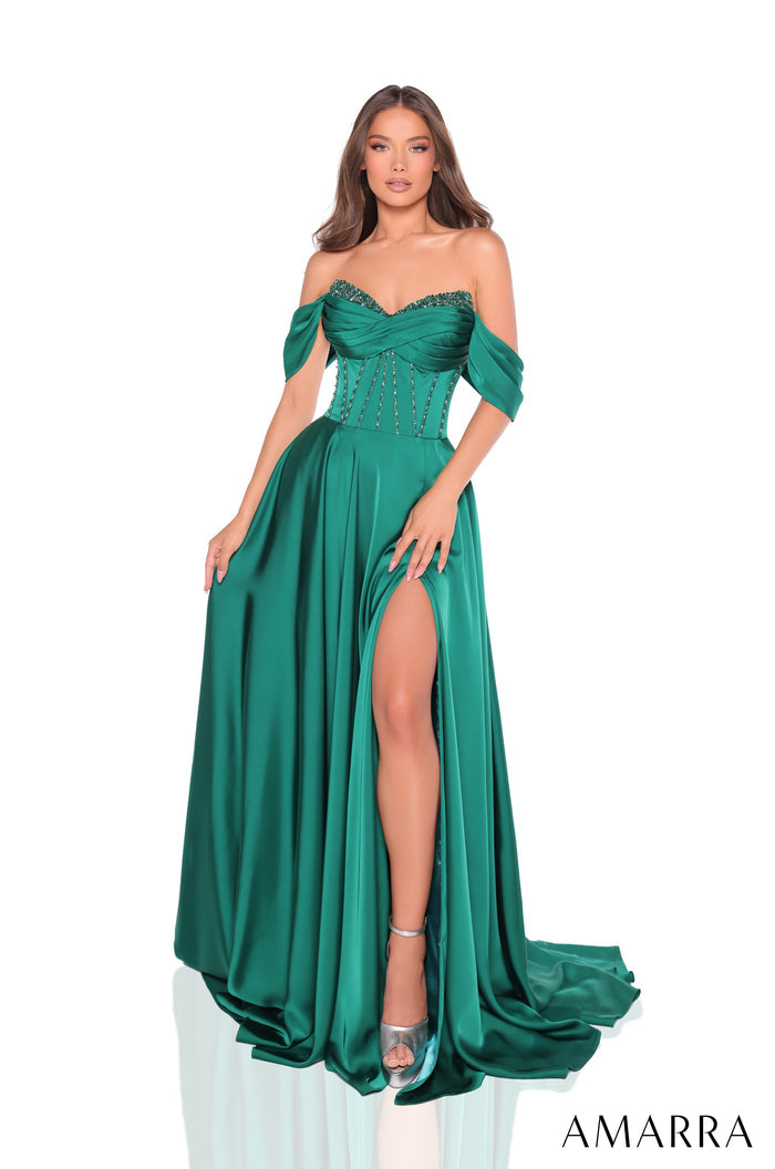 A model wears an emerald green off-shoulder evening gown with a high slit and beaded bodice.
