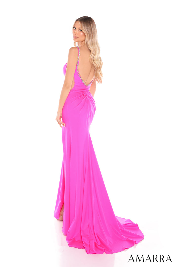 A model wears a vibrant pink floor-length gown with a low back and long train against a white background.