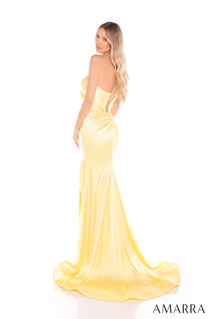 A slender figure wears a long, shimmering yellow strapless gown with a dramatic train.