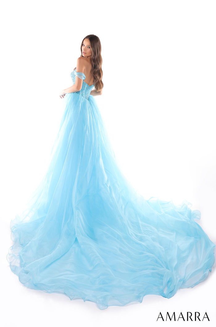 A blue off-shoulder ball gown with a voluminous tulle skirt and long, flowing train.