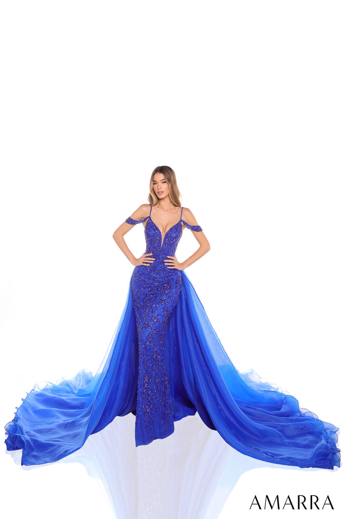 A fitted Royal Blue sequin gown with a dramatic tulle train, worn by a model against a white background.