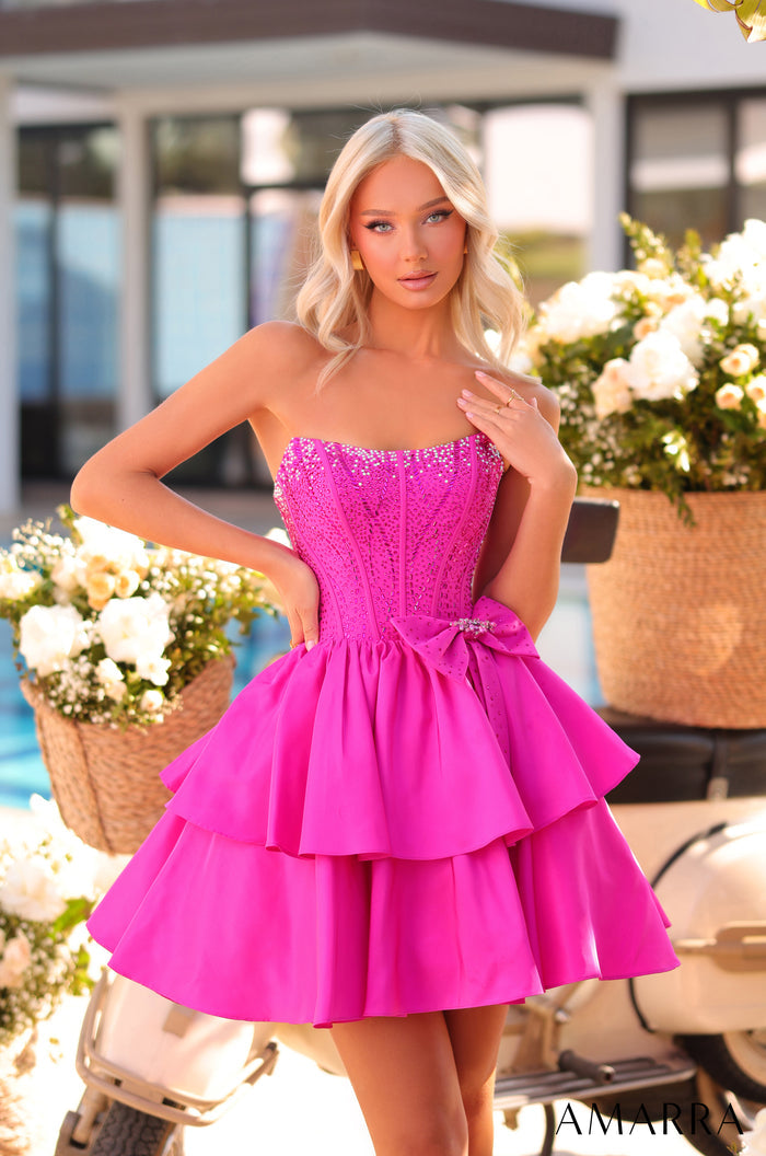 A model wears a strapless, tiered fuchsia dress with a beaded bodice and bow accent at a floral photo shoot.