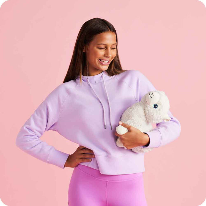 Teen girl smiling and holding Soft Warm Weighted Llama Plush Warmies